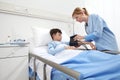Child lying in bed in hospital room and nurseÃÂ measuring his pressure withÃÂ sphygmomanometer Royalty Free Stock Photo